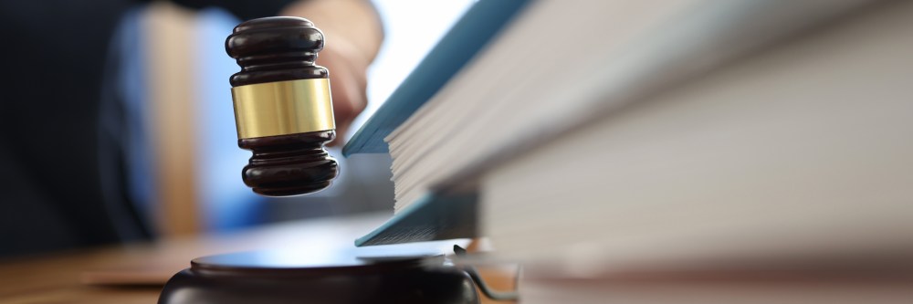 Wooden gavel for judge on table next to folder with documents.